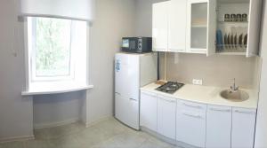 a kitchen with a white refrigerator and a sink at Apartment on Karla - Libknekhta in Yaroslavl