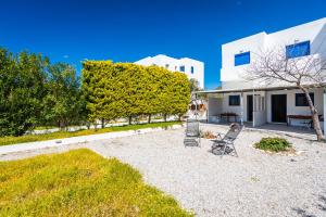 a yard with two chairs and a house at Play On The Sand in Adamantas