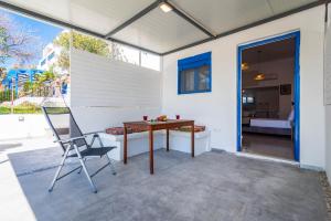 a patio with a wooden table and a chair at Play On The Sand in Adamantas
