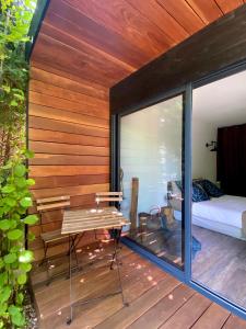 a wooden deck with a bed and a table at La Cabane de Troyes - Chambre d'hôtes in Troyes