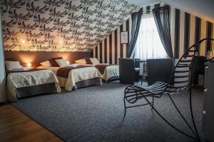 ein Hotelzimmer mit 2 Betten und einer Treppe in der Unterkunft Hotel Napoleon in Wróblew