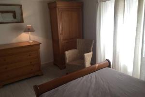 a bedroom with a bed and a chair and a dresser at La casa Trivala in Carcassonne