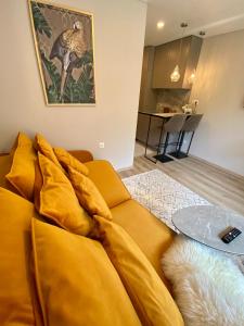 a yellow couch sitting in a living room at Modern Studio Juodkrante in Juodkrantė +14 photos