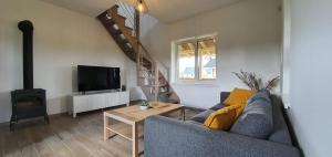 a living room with a couch and a tv and a staircase at Villa Monciske in Palanga