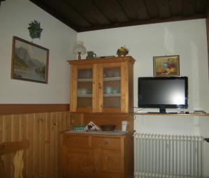 a living room with a tv and a wooden cabinet at Haus Schraml in Grundlsee