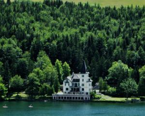 an island in the middle of a lake with a house at Haus Schraml in Grundlsee