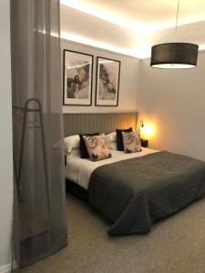 a bedroom with a large bed with two pictures on the wall at Blakeney House in Blakeney