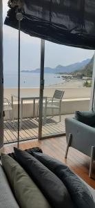 a living room with a view of the beach at Taormina SeaSuite Fondaco Parrino in Santa Margherita-Sant'Alessio Siculo