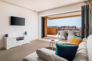 ein Wohnzimmer mit einem Sofa und einem TV in der Unterkunft Sotogrande Ribera del Marlin apartment in Sotogrande