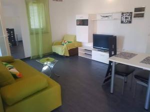 a living room with a yellow couch and a table at Sabljak in Kornić