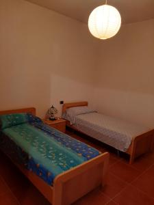 サンタンティーオコにあるAppartamento isola Sant'Antioco Sardegnaのベッドルーム1室(ベッド2台、シャンデリア付)