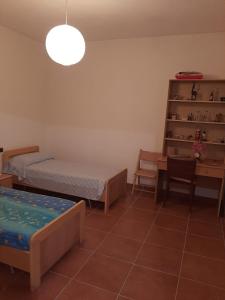 - une chambre avec 2 lits et une table avec un bureau dans l'établissement Appartamento isola Sant'Antioco Sardegna, à SantʼAntìoco