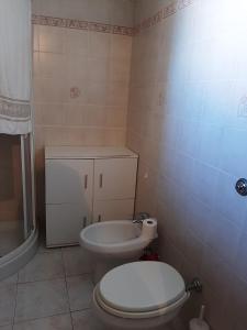 La salle de bains est pourvue de toilettes blanches et d'un lavabo. dans l'établissement Appartamento isola Sant'Antioco Sardegna, à SantʼAntìoco