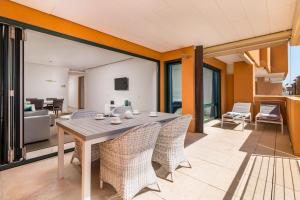 ein Wohnzimmer mit einem Holztisch und Stühlen in der Unterkunft Sotogrande Ribera del Marlin apartment in Sotogrande