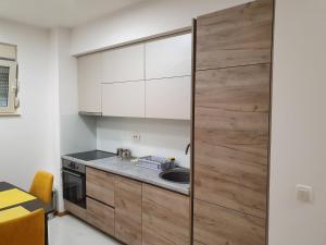 una cucina con armadietti bianchi e porta in legno di The Flat ,Budva a Budua