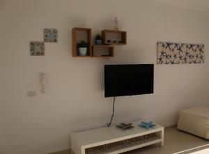 ein Wohnzimmer mit einem Flachbildfernseher an der Wand in der Unterkunft Casa CostaSud in Marina di Ragusa