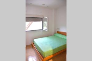 a small bedroom with a bed and a window at APARTAMENTOS GALLACH (LA ERMITA) in Chulilla