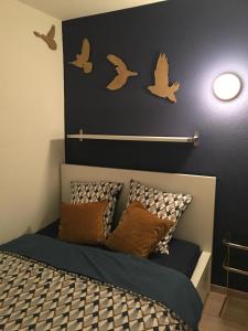 ein Schlafzimmer mit einem Bett mit Vögeln an der Wand in der Unterkunft Studio Cime de l'Est in Vérossaz