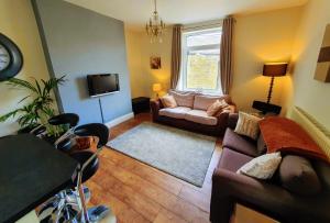 ein Wohnzimmer mit Sofa und Fernseher in der Unterkunft Bronte Cinema Cottage At Haworth in Haworth