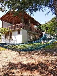 a hammock in front of a house at Green Leaves in Iraklitsa