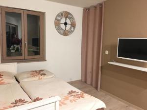 a bedroom with two beds and a clock on the wall at Studio Cime de l'Est in Vérossaz