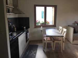eine Küche mit einem Tisch, einem Tisch und Stühlen in der Unterkunft Studio Cime de l'Est in Vérossaz