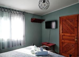 a bedroom with a bed and a television and a window at Green Leaves in Iraklitsa