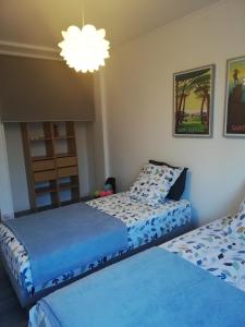 1 dormitorio con 2 camas y lámpara de araña en BEACH-CITY 3 PIECES, en Saint-Raphaël