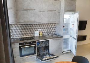 eine Küche mit einem Herd und einem offenen Kühlschrank in der Unterkunft Villa Ivanovic in Vir