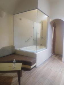 Motel Mykonos في بوبلا: غرفة مع حوض مع أريكة وطاولة