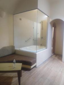 Habitación con bañera, sofá y mesa. en Motel Mykonos, en Puebla