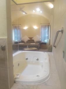 Motel Mykonos في بوبلا: حمام مع حوض كبير في الغرفة