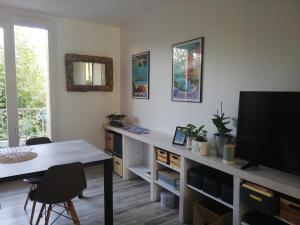 a living room with a table and a television at BEACH-CITY 3 PIECES in Saint-Raphaël