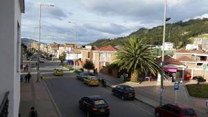 a city street with cars parked on the road at Hotel Abadia in Sogamoso