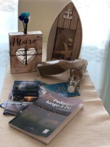 einen Tisch mit einem Buch, einer Schachtel und einigen Büchern in der Unterkunft Mare&Terra... Alloggi nel Delta in Polesine Camerini
