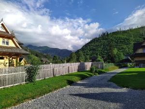 uma estrada de cascalho ao lado de uma cerca e uma casa em Kirowy Domek em Kościelisko