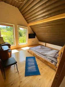un grande letto in una camera con soffitto in legno di Eco Resort Nad Karpatamy a Hrobyshche