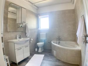 a bathroom with a sink and a tub and a toilet at Apartmani Carnizza in Ražanac +28 photos