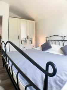 a bedroom with a large bed with a blue blanket at Apartmani Carnizza in Ražanac