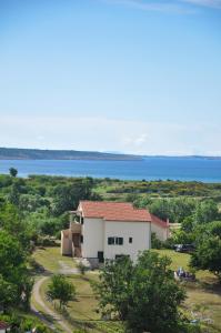 a white house with a view of the water at Apartmani Carnizza in Ražanac