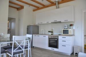 a kitchen with white appliances and a table and chairs at Apartmani Carnizza in Ražanac
