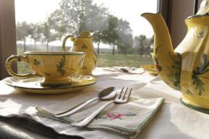 a table with plates and cups and utensils on it at B&B Magic in Dozza