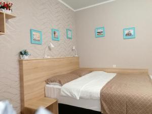 エッセントゥキにあるGuest House U Yuliのベッドルーム1室(ベッド2台付)が備わります。壁には絵画が飾られています。
