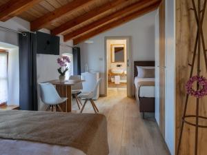 a bedroom with a bed and a table and chairs at Apartmaji in sobe Odlična hiša Štanjel in Štanjel