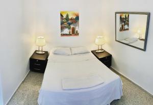 two beds in a room with two lamps and a mirror at Palmira Hostel in Tegucigalpa