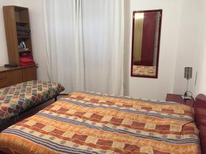 a bedroom with a bed and a mirror on the wall at Affittacamere D&B in Pogliano Milanese