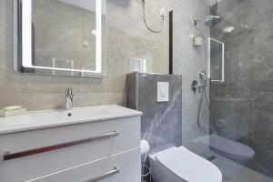 a bathroom with a shower and a sink and a toilet at Apartments Kolorina in Dubrovnik