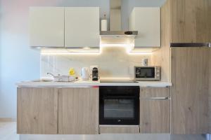a kitchen with a stove and a microwave at Apartments Kolorina in Dubrovnik