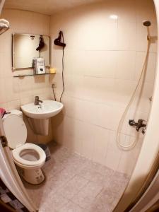 y baño con ducha, aseo y lavamanos. en Kenting Airport Homestay 機場民宿, en Hengchun