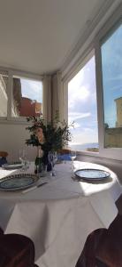 a table with a white table cloth on it with a window at La Casetta e Mammà in Positano
